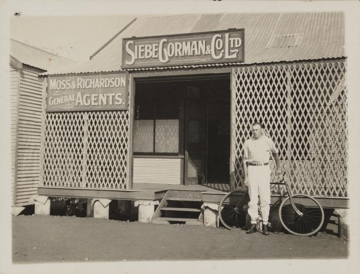 A man standing outside a shop front. 